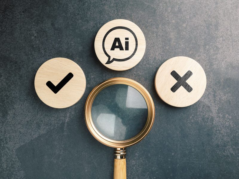 Magnifying glass examining AI symbol with check and cross mark representing right and wrong information detection, artificial intelligence verification concept, accuracy and error review